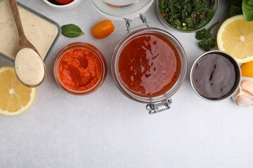 Different marinades and products on light table, flat lay. Space for text