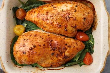 Baked chicken fillets with vegetables and marinade on table