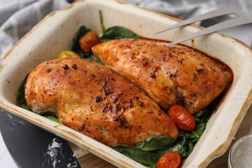 Baked marinated chicken fillets on white table, closeup