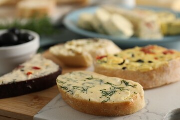 Different types of tasty butter and bread on table, closeup