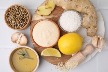 Flat lay composition with fresh marinade and different ingredients on white tiled table