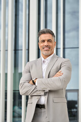 Vertical portrait of smiling confident middle aged professional entrepreneur business man ceo executive leader, elegant mature businessman manager company owner wearing suit standing outdoors. - 783164737
