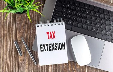 TAX EXTENSION text on notebook with laptop, mouse and pen