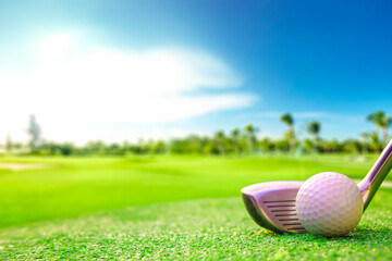 Golf ball placed on grass with sky background.