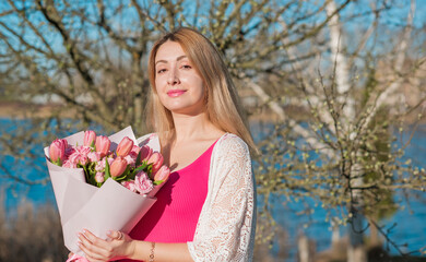 Natural women's beauty without plastic surgery and no photoshop. European lady mixed race. Lady of middle age as she is with bouquet of flowers