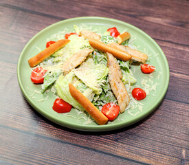 Caesar salad close-up. Grilled chicken breast slices, green romaine salad leaves, croutons and Parmesan, the classic recipe