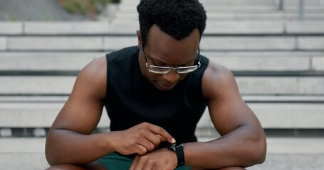 Black man, smart watch and stairs with fitness, exercise and training with break and checking time. Steps, African person and athlete with goals, progress and tracker with hobby and app with workout