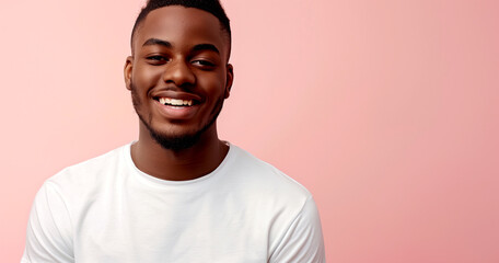 A portrait of a smiling African American man against a pink studio backdrop
