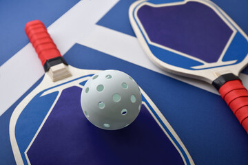 Obraz premium Detail of blue and red pickleball paddles on playing court