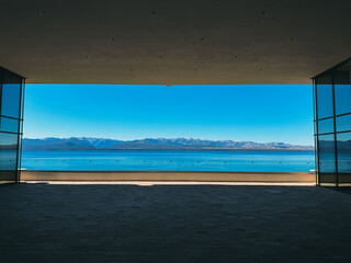 A large open space with a view of the ocean and mountains. The sky is clear and blue