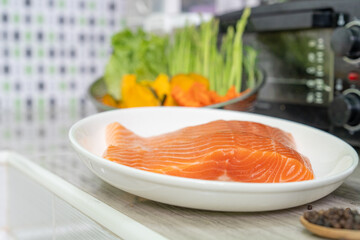 Fresh salmon fish with paper and vegetable prepaering to cooking.