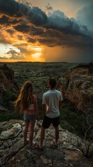 Young Couple Enjoying a Breathtaking Sunset Over Rugged Canyon Landscape