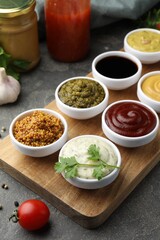Many different sauces and products on grey table