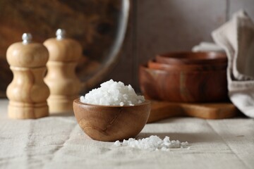 Organic salt in wooden bowl on table