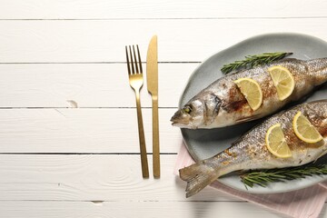 Delicious baked fish served on white wooden table, top view. Space for text