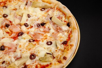 Delicious Italian pizza with artichokes, olives, prosciutto, and mozzarella cheese.