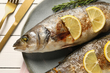 Delicious baked fish served on white wooden table, top view