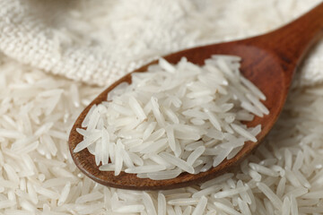 Raw basmati rice and spoon, closeup view