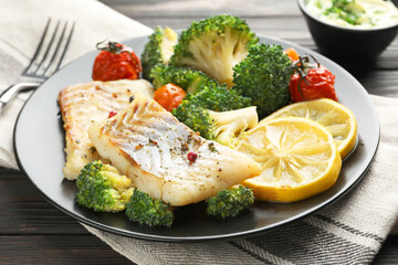 Tasty cod cooked with vegetables served on table, closeup