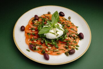 Fresh Caprese Salad with Tomatoes, Basil, Mozzarella, and Olives on White Plate