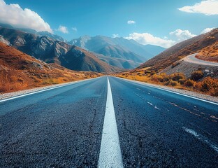 A long, empty road with a mountain range in the background