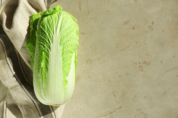 Fresh ripe Chinese cabbage on gray textured table, top view. Space for text