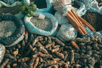 Assorted raw agricultural produce including cinnamon bark, lime, turmeric, clove, peppercorns and...
