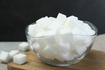 White sugar cubes in glass bowl on grey table