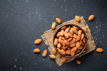 Almond nuts in bowl at black background. Top view. - 783199787