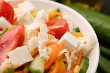 Tasty salad with Chinese cabbage, carrot, cheese, cucumber and tomato on table, closeup