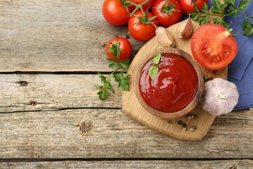 Tasty ketchup, fresh tomatoes, parsley and spices on wooden table, flat lay. Space for text