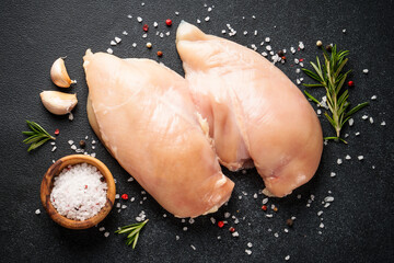 Chicken meat. Raw chicken breast with spices at black table. Top view. - 783202160