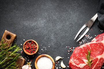 Beef steak with spices on black background. Ribeye steak raw meat. Top view with copy space. - 783204994