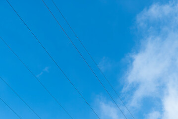 冬の青空に真っ直ぐ横切る電線　シンプル写真