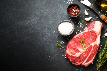 Foto op Plexiglas Meat steak. Beef steak dry aged with spices on black background. Top view. © nadianb