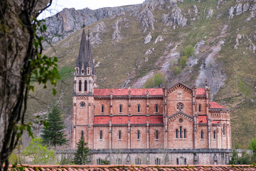 A tall structure standing in Covadonga, Asturias, featuring a grand building with a steeple...