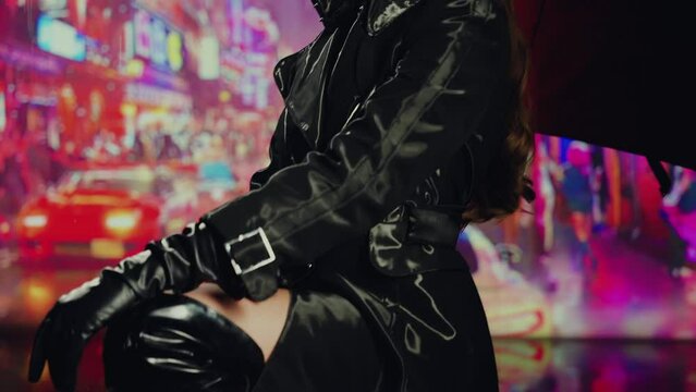 Dark shadow silhouette adult girl fashion model posing under umbrella in rain night city street red neon light. young woman beauty sexy face enjoys water drops falling from sky. Black dress coat 4k