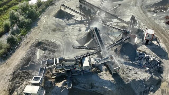 Aerial drone video of Gravel separator machine separates stone material into various fractions. Stone crusher plant machine. Conveyor belt in work process. Extraction of aggregates or gold from river