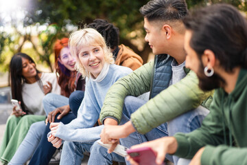 A multicultural group of students enjoys a lively discussion and shared laughter in an outdoor...