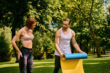 A woman in sportswear, with a personal trainer exercising in a park, showing determination and...