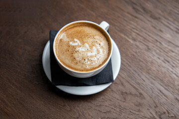 Close-Up View of a Spoiled Cappuccino With bad Curdled Milk Foam on a Wooden Table