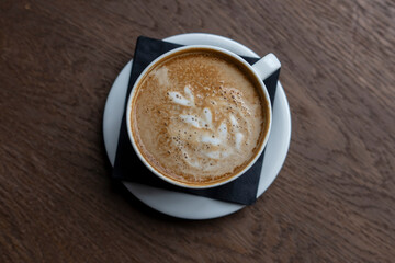 Close-Up View of a Spoiled Cappuccino With bad Curdled Milk Foam on a Wooden Table