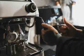 Barista Steaming Milk With a Coffee Machine Pitcher in a Modern Cafe