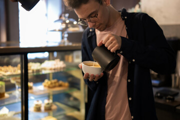 Barista Perfecting Latte Art During a Cappuccino Pour in a Cozy Cafe Setting