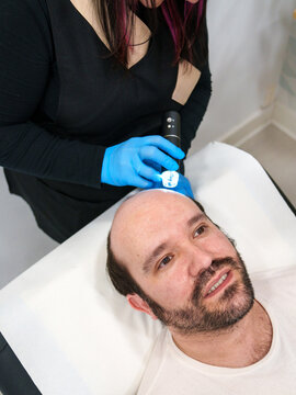 Clinician conducting a detailed dermascope analysis of patient's scalp.