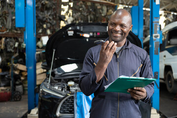 male worker talking on smartphone with customer in garage