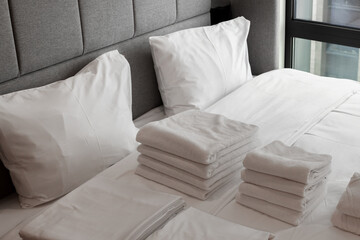 Clean towels on the bed in a hotel room, the bed iwith clean white pillows and sheets in the apartment. Close-up