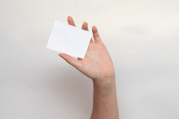 Mano femenina sosteniendo una tarjeta en blanco