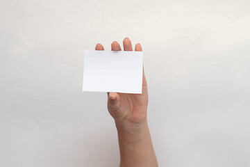 Una mano sosteniendo una tarjeta en blanco