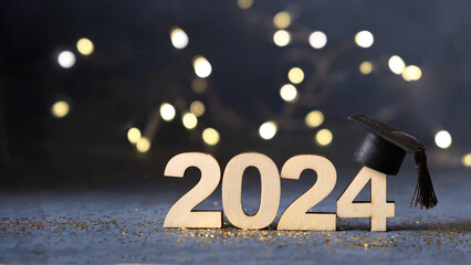 Class of 2024 concept. Number 2024 with graduated cap and bokeh lights banner. - obrazy, fototapety, plakaty
